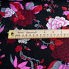 Create something stunning with this Designer Silk Crepe de Chine in florals of pinks, red, white, burgundy and grey upon a black background. Photo with ruler to depict floral size.