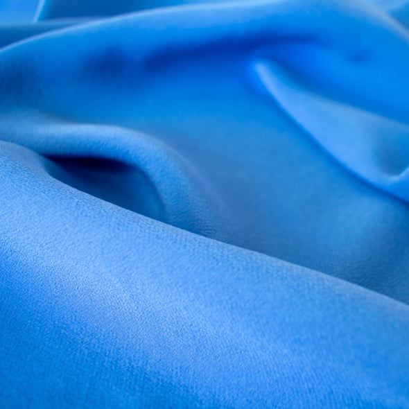 The soft, semi-textured fluid drape of this stunning French blue crepe will create a lovely dress or top.  Close up image.