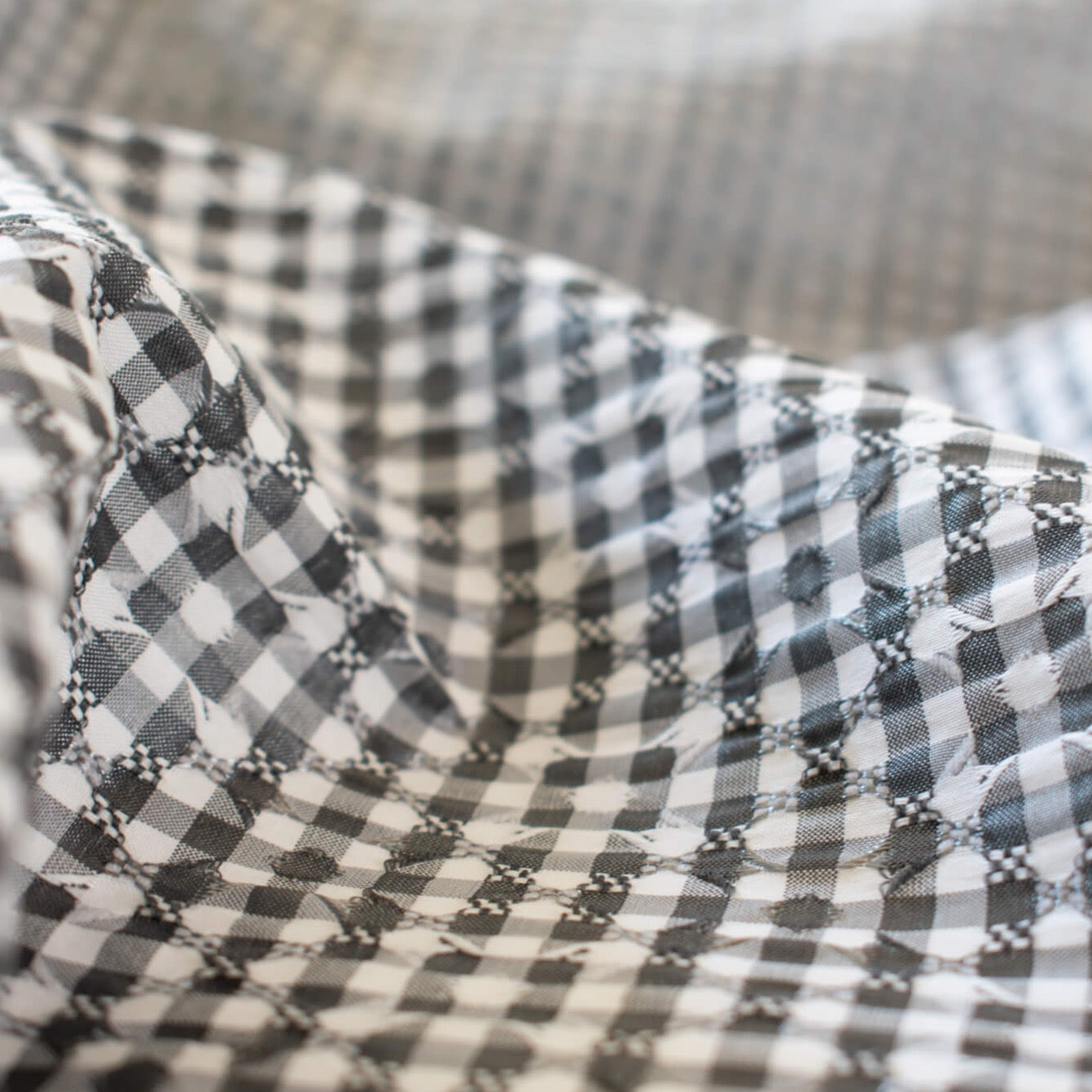 Gingham never looked so good!  Designer, black and white stretch woven has a dobby weave creating a geometric pattern which transforms the fabric into something truly special. This fabric has bit of a vintage vibe and is soft with a textured pattern and stretch along the selvedge.  close up image