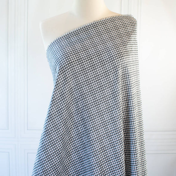 Gingham never looked so good!  Designer, black and white stretch woven has a dobby weave creating a geometric pattern which transforms the fabric into something truly special. This fabric has bit of a vintage vibe and is soft with a textured pattern and stretch along the selvedge.   image of fabric draped on dressform