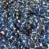 Designer Italian Matte Jersey Knit Fabric in a modern geometric print of abstract black squares se against a dark creme background.