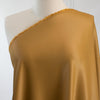 Enjoy a bit of 'Old Hollywood Glamour' in this dark gold stretch crepe back satin from a LA Designer. This satin is soft with a smooth hand and gorgeous sheen on the face side and a textured hand on the crepe back.  Bring out your inner designer and use both sides of the fabric to create something special.   Fabric on dressform.