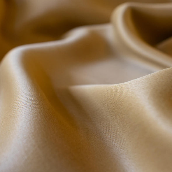 Enjoy a bit of 'Old Hollywood Glamour' in this dark gold stretch crepe back satin from a LA Designer. This satin is soft with a smooth hand and gorgeous sheen on the face side and a textured hand on the crepe back.  Bring out your inner designer and use both sides of the fabric to create something special.   Close up image.