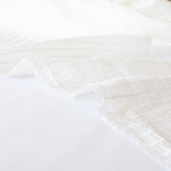 You will be dreaming of summer in this soft, sheer designer woven fabric.  This feels so good against the skin, a must have for summer dresses and tops. Gorgeous sewn up in a loose fitting garment or take advantage of the stripe and go for a bias cut!  Fabric has a white jacquard horizontal stripe against a white sheer background.  Image of selvedge.