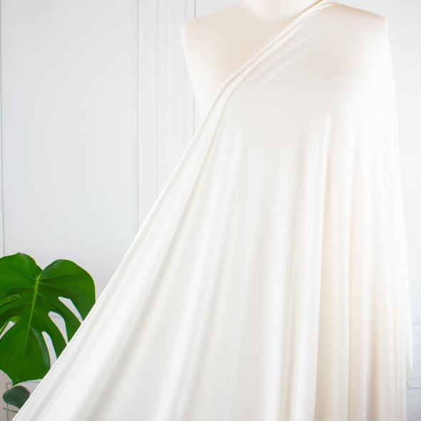 Casual and elegant, perfect for the popular flowy cardigan or wide leg pant.  Off white tissue jersey knit that is soft and flowy. Very thin hand, light and translucent from a Los Angeles designer. Fabric draped on dress form.