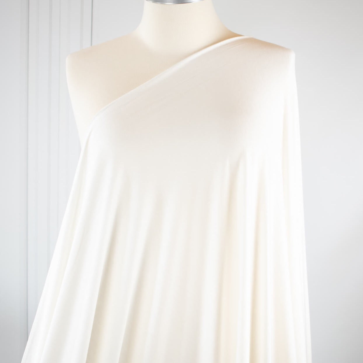 Casual and elegant, perfect for the popular flowy cardigan or wide leg pant.  Off white tissue jersey knit that is soft and flowy. Very thin hand, light and translucent from a Los Angeles designer. Fabric draped on dress form.