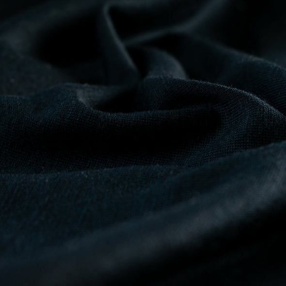 Merino Wool Jersey knit in a gorgeous blue/black.   This fabric has a soft hand and is light and flowy, perfect for a top or cardigan. It makes a perfect layering piece. A generous width at 56 inches and a mechanical stretch.  Close up image.