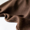 Merino Wool Jersey knit in a gorgeous chocolate brown.   This fabric has a soft hand and is light and flowy, perfect for a top or cardigan. It makes a perfect layering piece. A generous width at 63 inches and a mechanical stretch.  Image of selvedge edge.