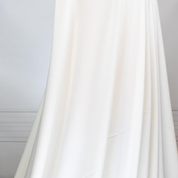 Power Suiting never felt so good!  NYC designer fine twill is a soft touch with a semi-textured hand. Not only is it in an easy to care for poly/lycra blend but it has a bit of stretch for comfort. This fine suiting is an opaque soft powder white that flatters!   Image of draped fabric.