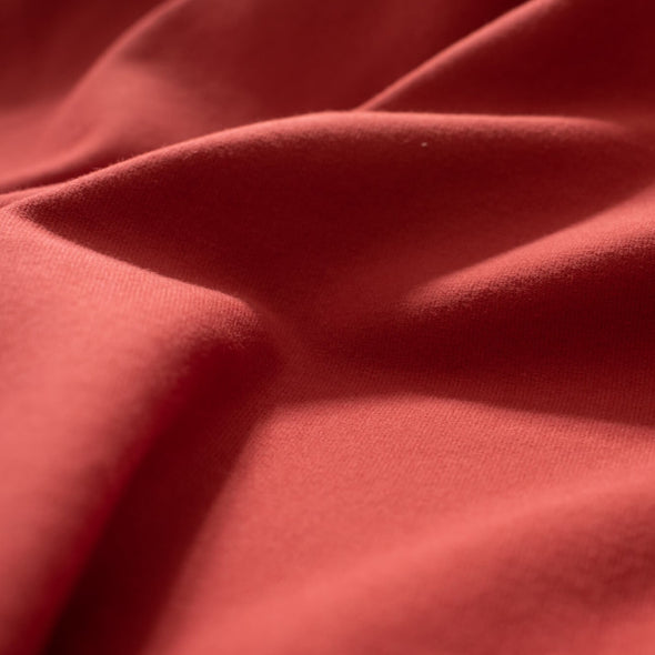 NY Designer cotton/lycra jersey in a warm scarlett red is super soft and super wide!  It is on the lighter side of a mid-weight and has excellent stretch and recovery. A cotton knit with lycra is perfect for sewing up a gorgeous top for warmer weather! Closeup image