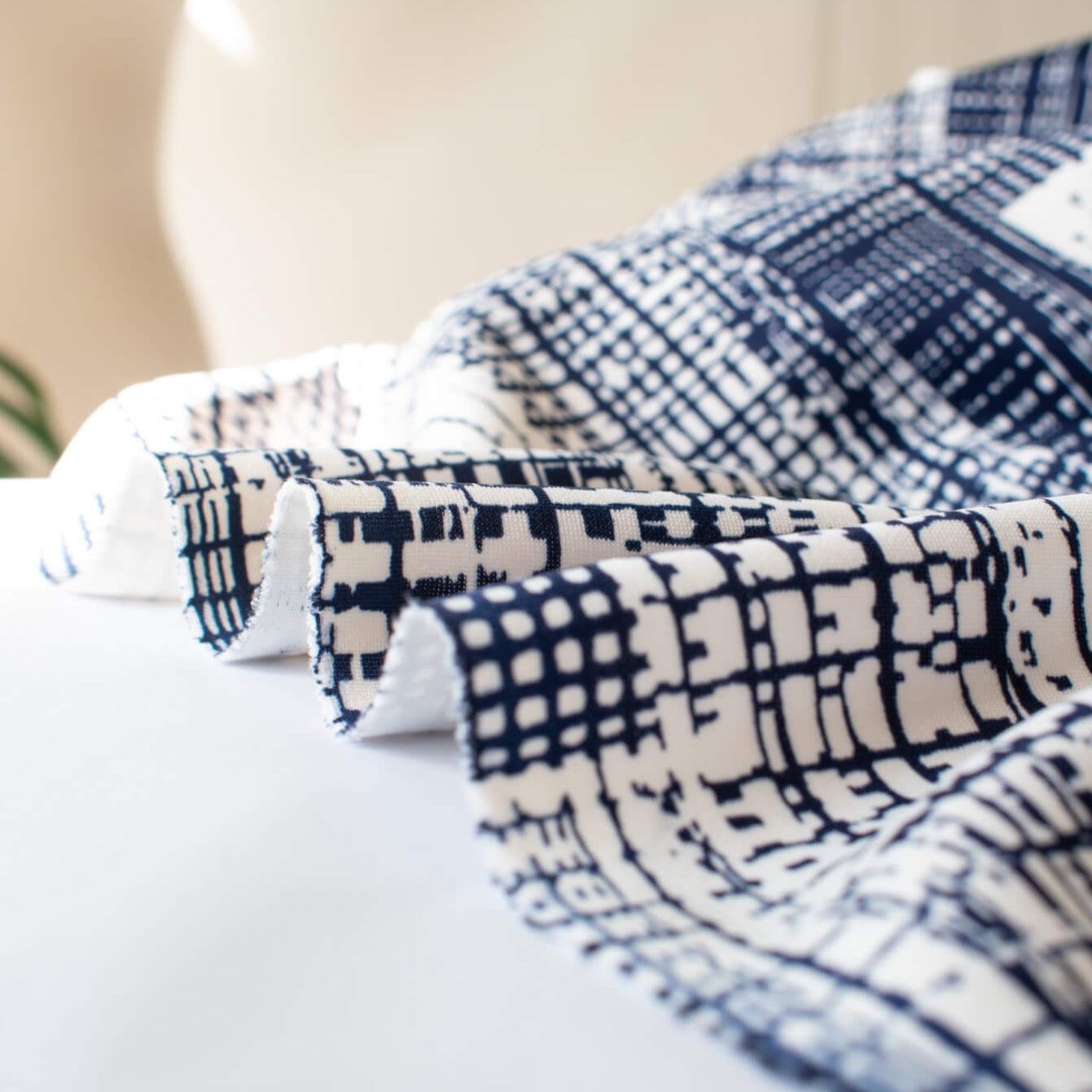 Modern, smooth and a dream to sew! This white and navy abstract plaid techno knit is not as thick as a scuba knit but does lay gently over our curves.  Choose this fabric as you would a double knit as it does have some fullness. Perfect for a pencil skirt, fitted sheath dress or a top. Close up image of fabric selvedge