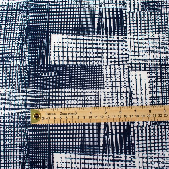 Modern, smooth and a dream to sew! This white and navy abstract plaid techno knit is not as thick as a scuba knit but does lay gently over our curves.  Choose this fabric as you would a double knit as it does have some fullness. Perfect for a pencil skirt, fitted sheath dress or a top. Image of fabric scale with ruler.