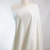 Steal the show in this NYC Designer pebble satin. A gorgeous light to medium weight off-white rayon satin that shimmers. Create a portrait worthy slip dress, bias skirt, or top! Longer image of fabric draped on dressform