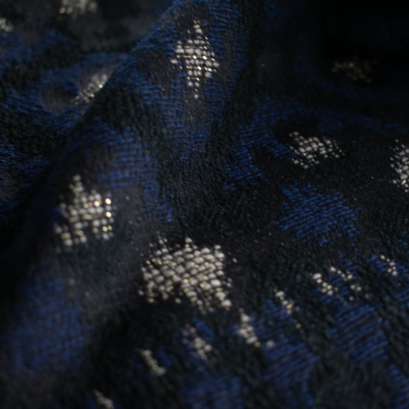 The golden metallic threads of this Italian jacquard create a diamond pattern, bordered in a black diamond shape that is just stunning.  A soft textured hand and medium weight make it perfect for a stylish jacket!  close up image