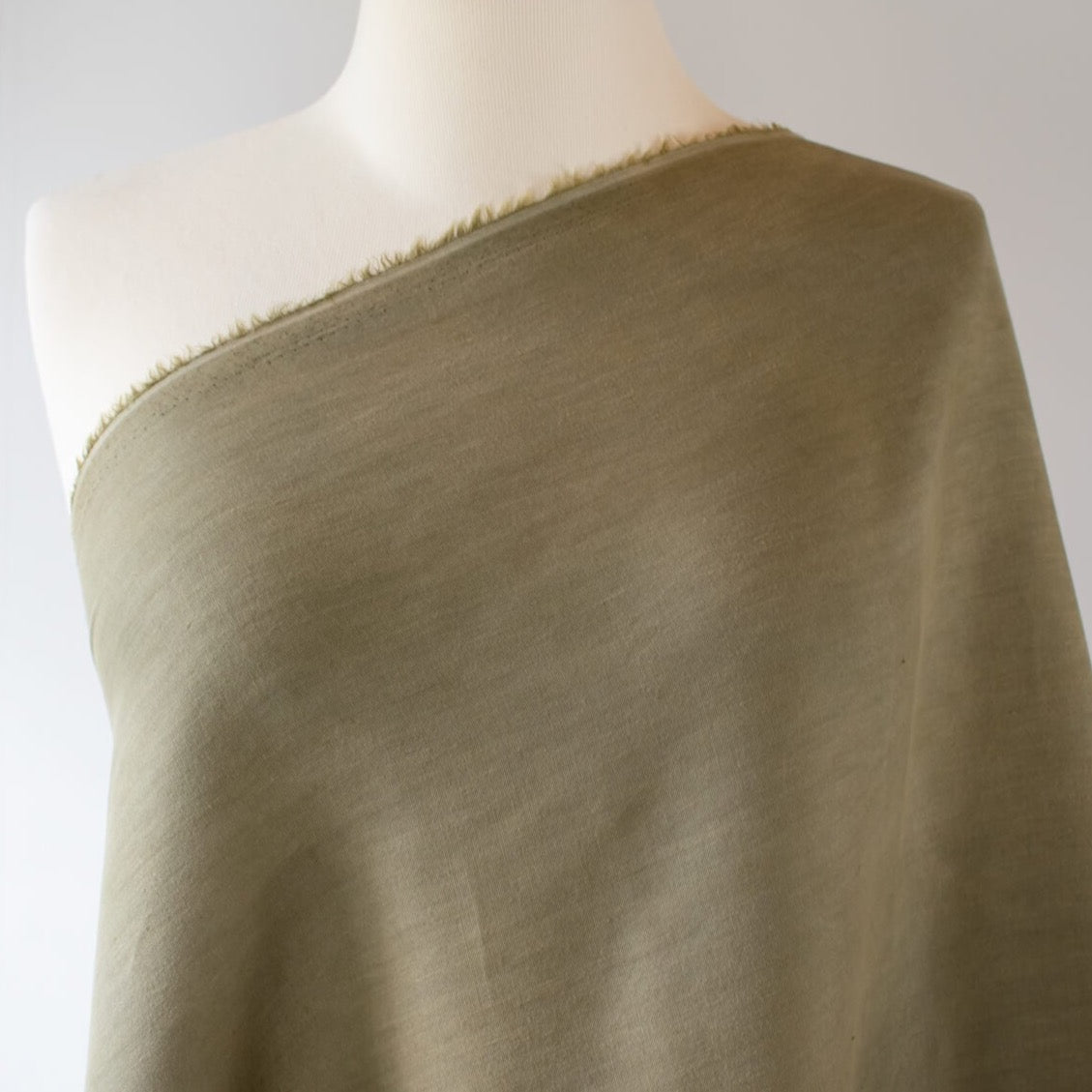 A linen so soft you will want to wear it every day!   And it's a beautiful soft green that will have you thinking of Summer afternoons in your garden.  This color pairs so well with bright white.  Image of fabric on dress form.