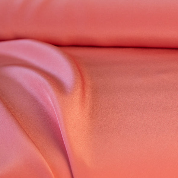 Universally flattering, salmon pink crepe de chine. The soft, semi-textured fluid drape will create a lovely dress or top for your next sewing adventure. close up image