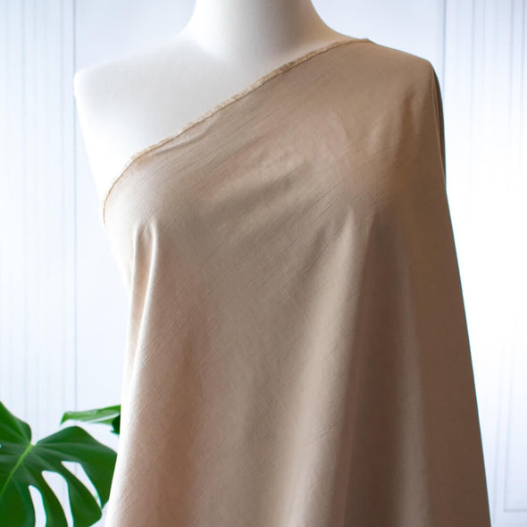 Washed linen blend has a soft, textured, slightly crisp hand, and some drape from the rayon. Make up a gorgeous top, dress or skirt that stands out!  Translucent with a washed look and pleasing slubbed texture, may need lining for dresses and skirts. Fabric draped on dress form.
