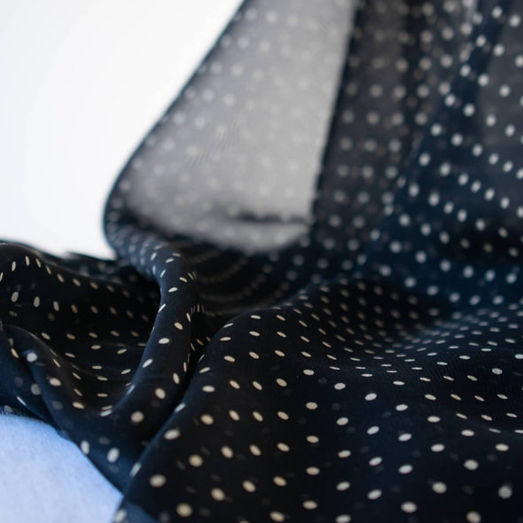 Add elegance to your project with this lovely black and Vanilla Creme 100% Silk Polka Dot Chiffon. Chiffon is sheer, has a beautiful drape and is popular in blouses, gowns, lingerie, flowy overlays, scarves, even trim. Perhaps you have seen it used as trim in those fabulous French Jackets! A technique we can't wait to try. Photo revealing sheerness of this fine fabric.