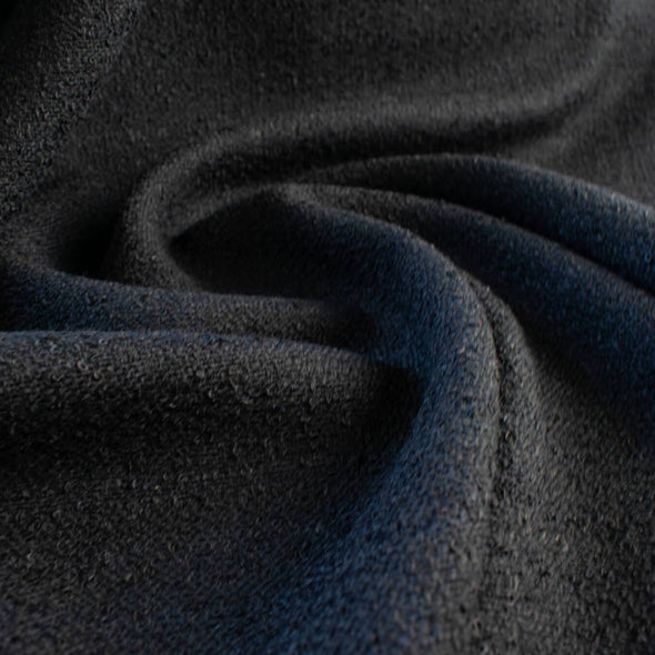 Couture Designer Wool Blend Flat Boucle fabric in black. Perfect for a French Jacket! - swirled in picture to show fabric body.