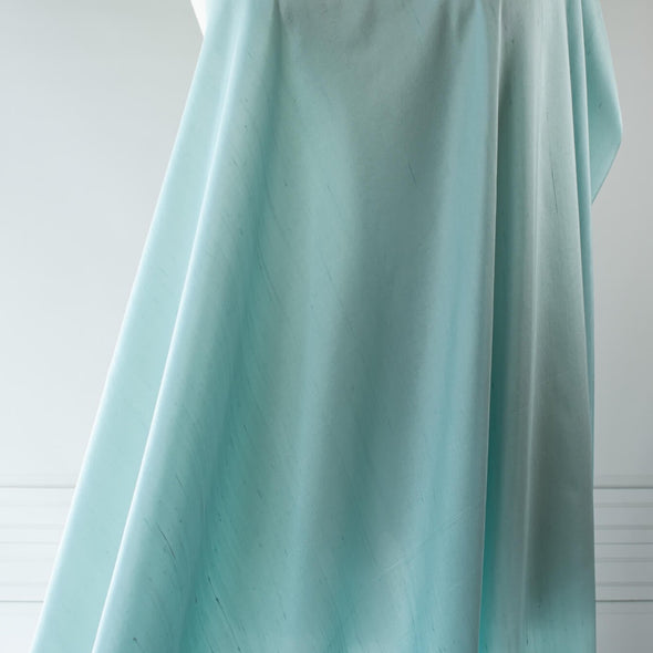 Elegant and dreamy this crystal blue, light weight, silk shantung from a Beverly Hills Couture house is lustrous with a soft slightly textured hand. The suppleness of this silk just feels good against your skin and would make an elegant dress, skirt, gown, suit or top. Image of fabric drape. 