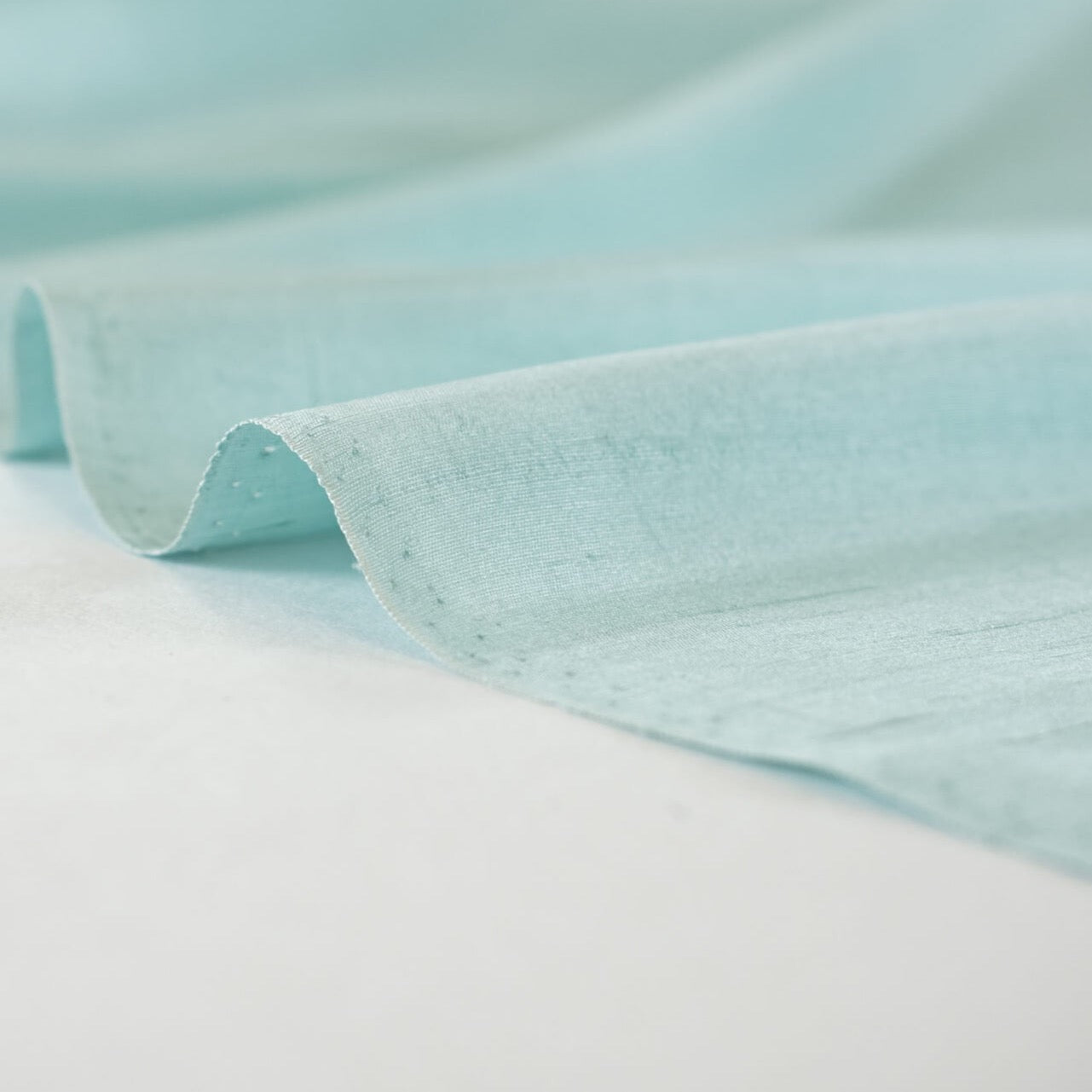 Elegant and dreamy this crystal blue, light weight, silk shantung from a Beverly Hills Couture house is lustrous with a soft slightly textured hand. The suppleness of this silk just feels good against your skin and would make an elegant dress, skirt, gown, suit or top. Image of selvedge.