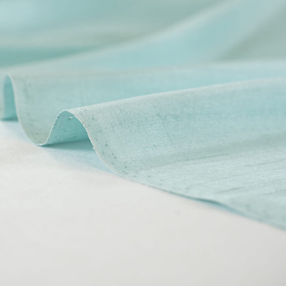 Elegant and dreamy this crystal blue, light weight, silk shantung from a Beverly Hills Couture house is lustrous with a soft slightly textured hand. The suppleness of this silk just feels good against your skin and would make an elegant dress, skirt, gown, suit or top. Image of selvedge.